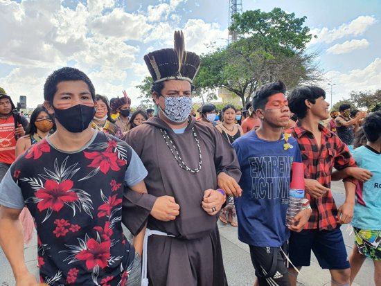 Capuchin Franciscan Father Mateus Bento dos Santos, in headdress, joins others during a march for Indigenous rights in early September in Brasilia, Brazil. An estimated 6,000 Indigenous people along with Catholic religious leaders camped in Brazil's capital for more than a month, hoping to convince the country's Supreme Court to reject a bid to strip Indigenous land rights.