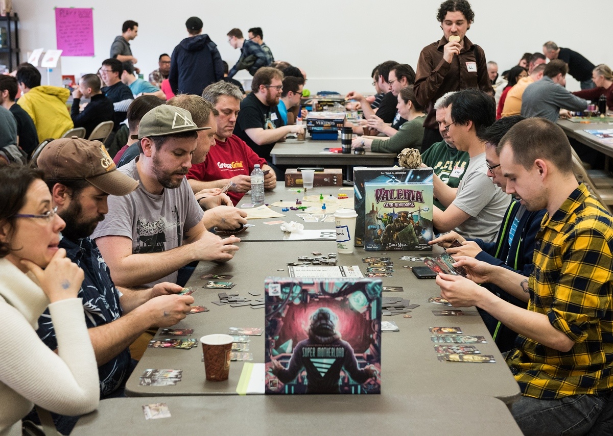 People at a convention playing various tabletop roleplaying game systems