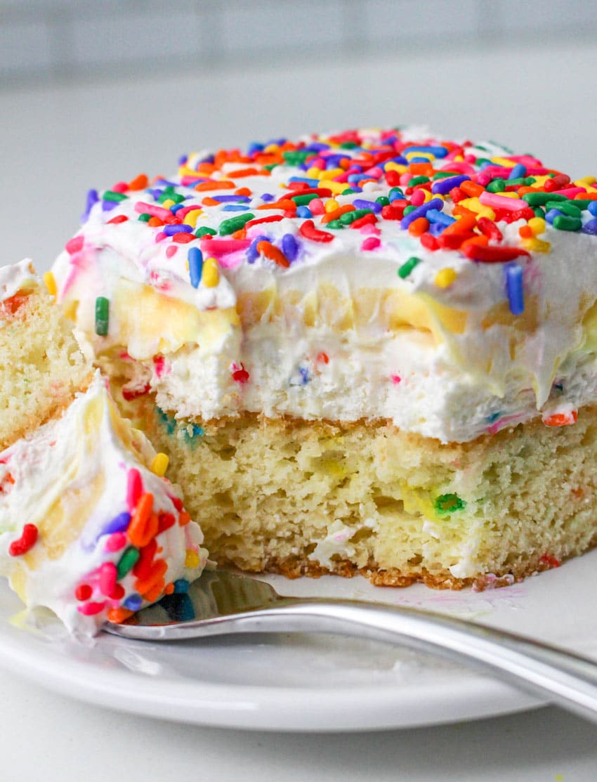 a slice of a layered funfetti cake dessert on a white plate