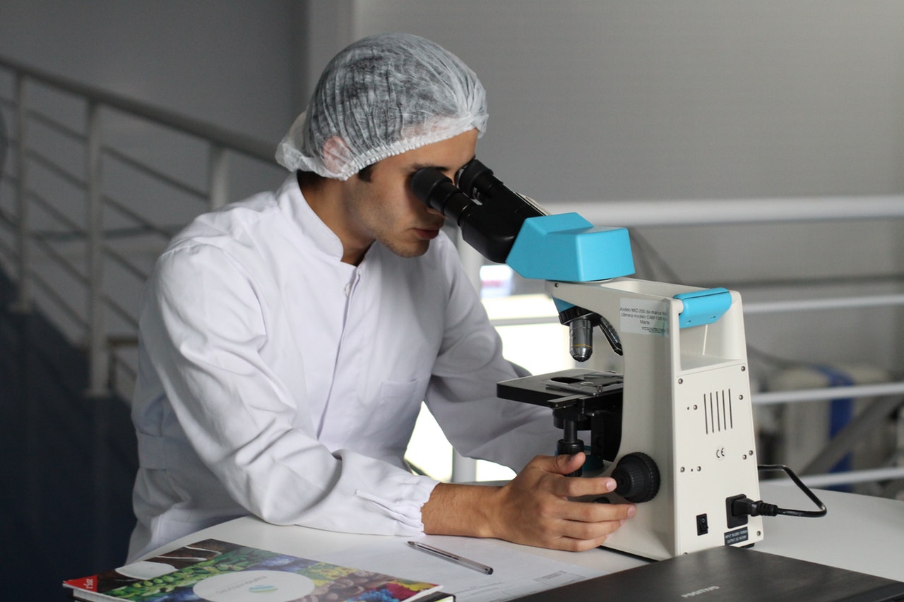 Research scientist looking at samples through microscope