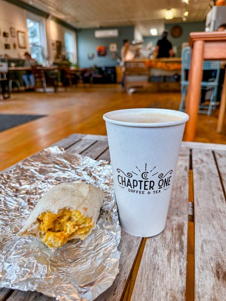 Coffee in a to-go cup and a half-eaten breakfast burrito at Chapter One Coffee
