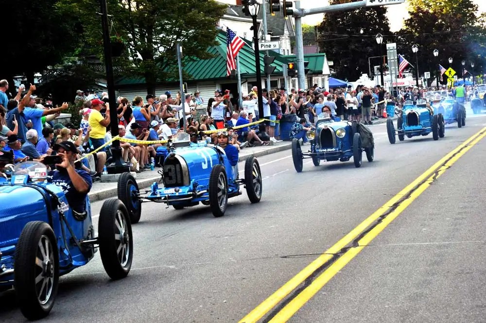 Vintage Bugatti race cars driving through downtown Watkins Glen during the annual Grand Prix Festival parade.