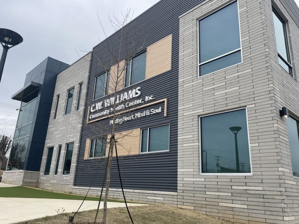 Exterior view of C.W. Williams Community Health Center, featuring a modern design with large windows and a sign highlighting its services.