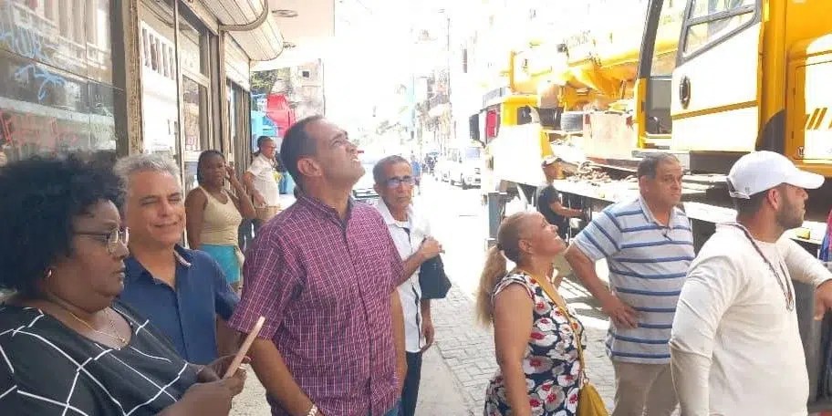 Transeúntes y trabajadores observan el edificio que sufrió un derrumbe parcial, este martes