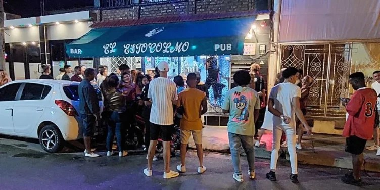 Jóvenes frente a la entrada del bar Estocolmo, en la ciudad de Guantánamo
