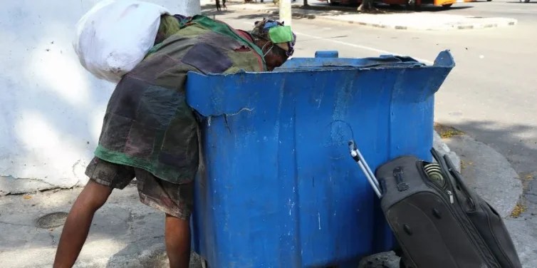 Una persona in hogar revisa un tanque de basura en La Habana