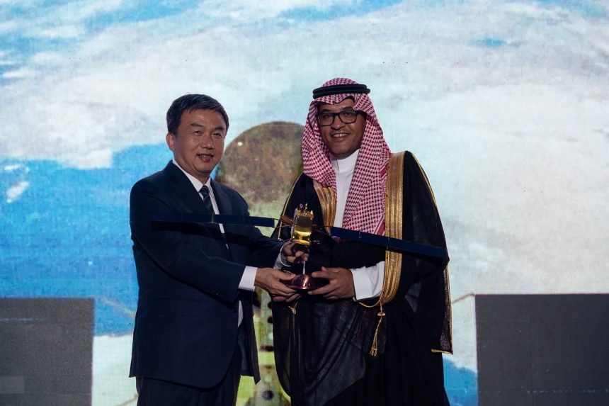 ممثلان عن عرب سات وشركة سور الصين العظيم يحملان نموذج قمر صناعي