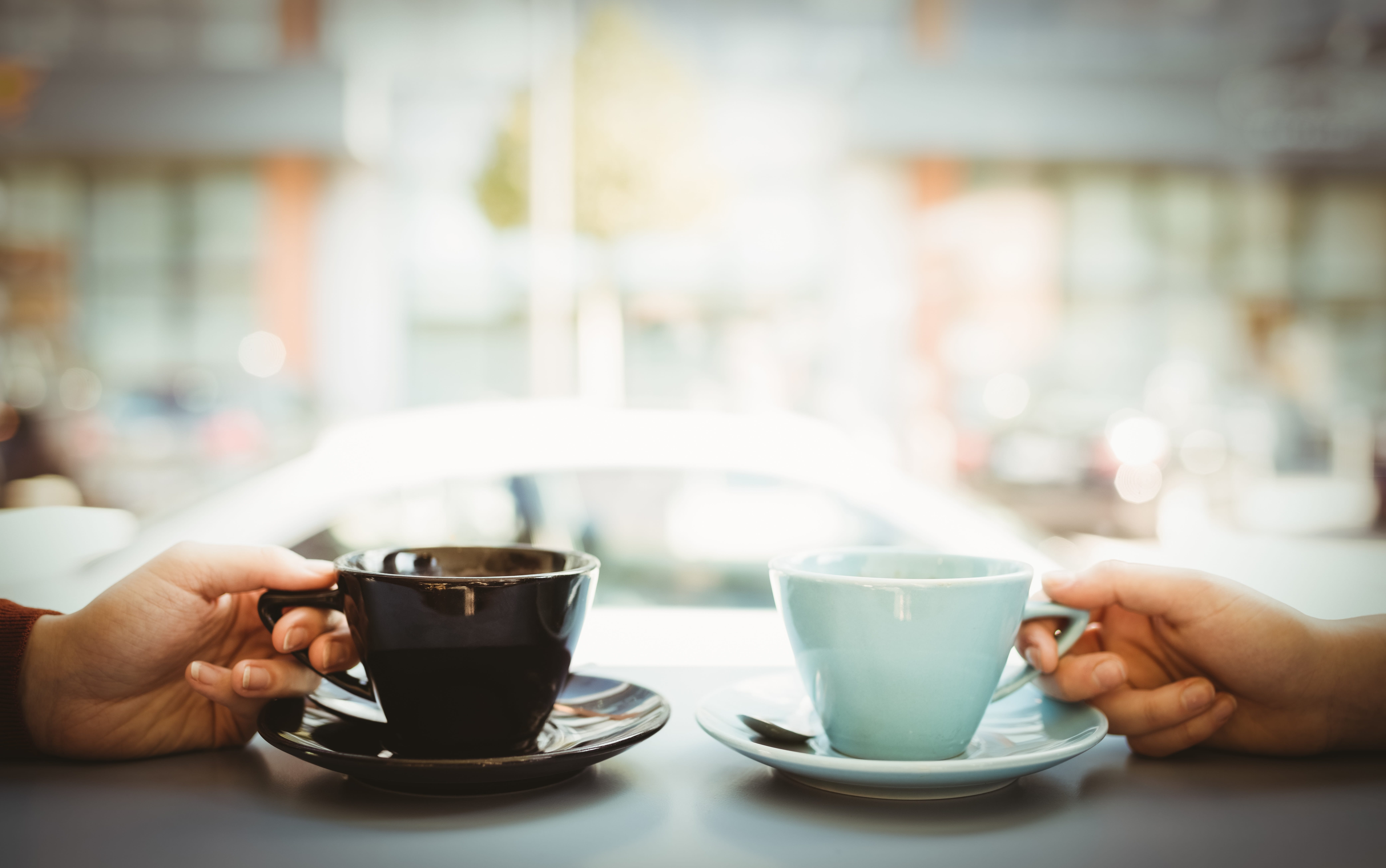 A customer walks in, marches up to the counter, assumes the demeanor of a connoisseur, and demands: Friends holding cup of coffee - FundCalibre