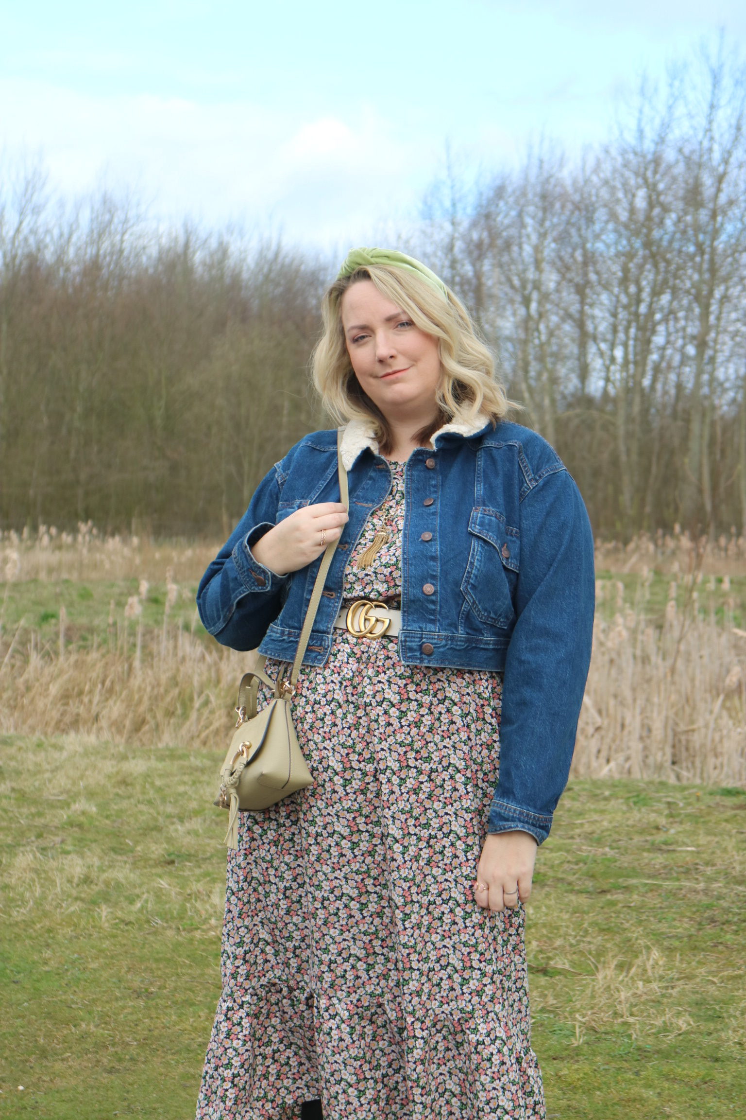 lucy in a field in a floral dress and headband