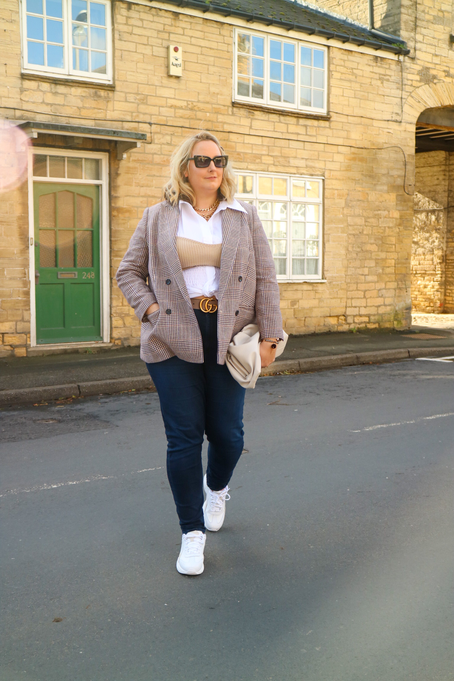 Lucy wearing a blazer, shirt, jeans and a knit bandeau top