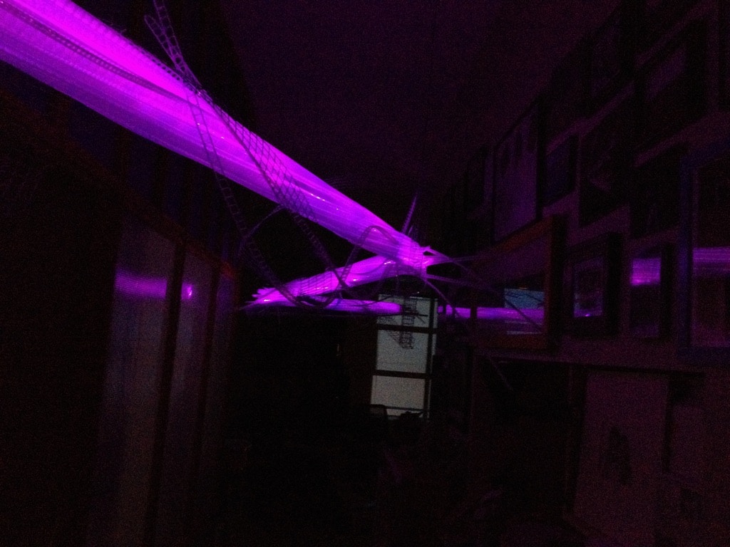 22-foot-long pendant LED light sculpture, changing colours.  LED lights run through three acrylic tubes joined with heavy gauge wire, wrapped with strips of steel mesh and polycarbonate.  stunning; completely original.