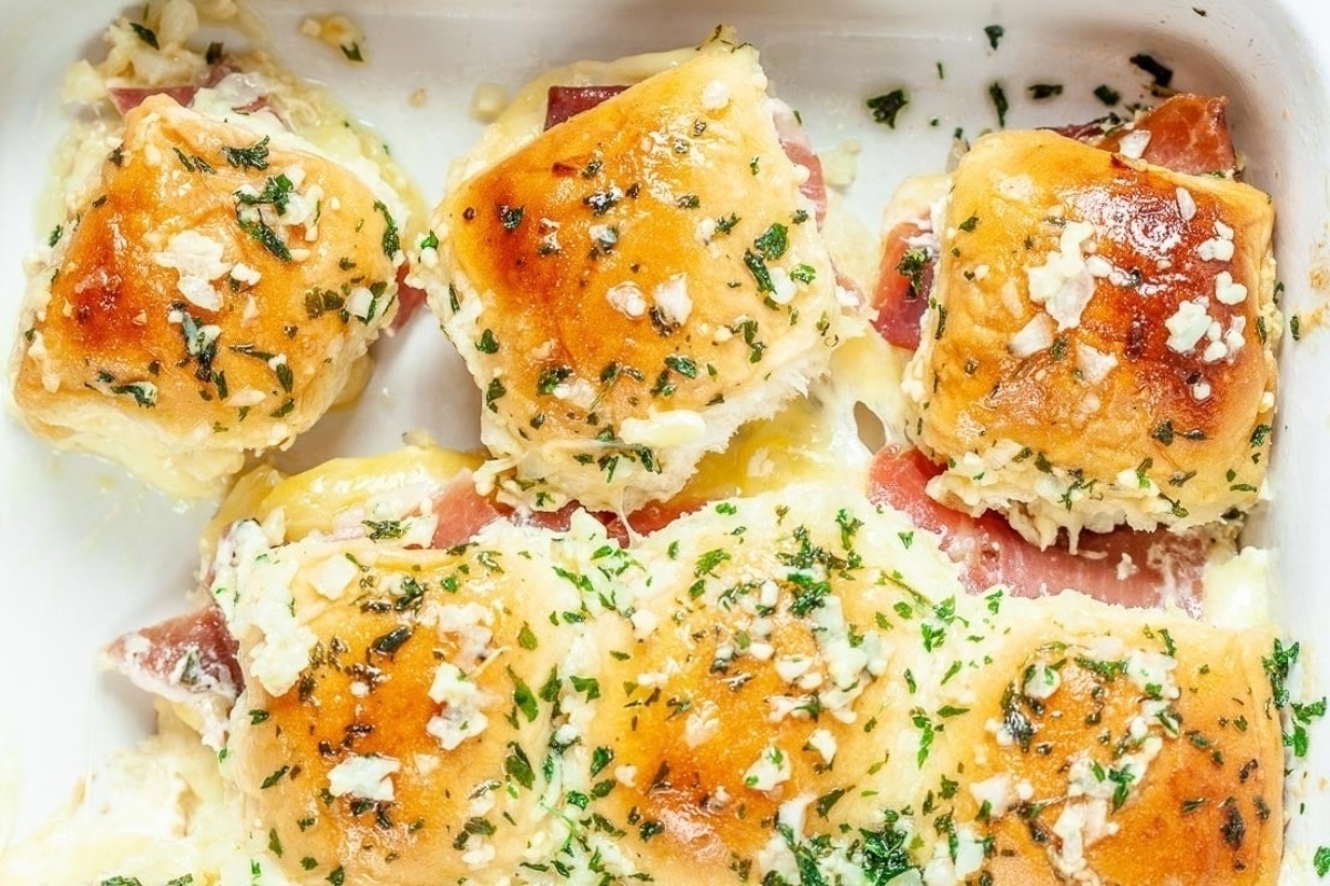 Ham and cheese sliders, a delicious combination of savory ham and gooey cheese, served in a white dish. Explore slider recipes to create these irresistible bite-sized treats.